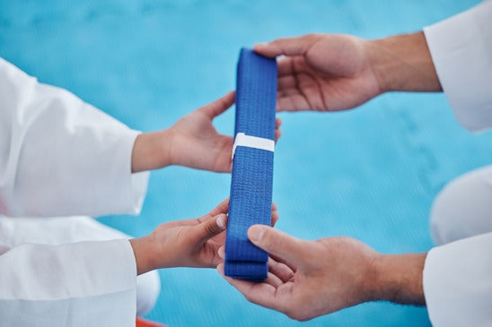 Martial artist receiving blue belt